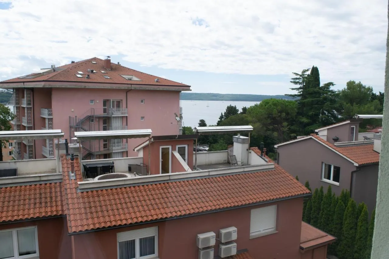 Pogled z naše terase čez sosednje hiše na zaliv